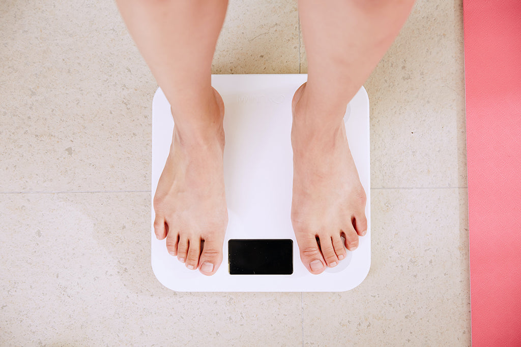 Vu de haut d'une femme se pesant sur une balance